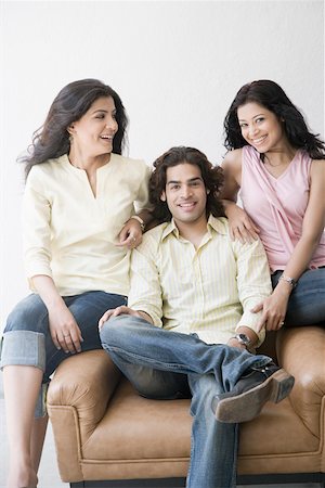 Two young women and a young man sitting together and smiling Stock Photo - Premium Royalty-Free, Code: 630-01874702