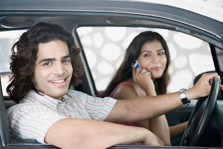 Close-up of a young couple sitting in a car and smiling Stock Photo - Premium Royalty-Free, Code: 630-01874754