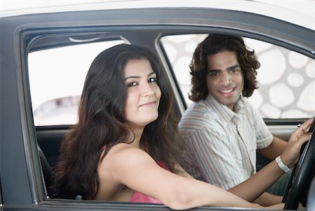 Side profile of a young couple sitting inside a car and smiling Stock Photo - Premium Royalty-Free, Code: 630-01874756