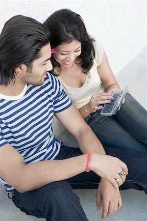 simsearch:630-01874614,k - High angle view of a young woman operating a mobile phone with a young man sitting beside her Stock Photo - Premium Royalty-Free, Code: 630-01874848