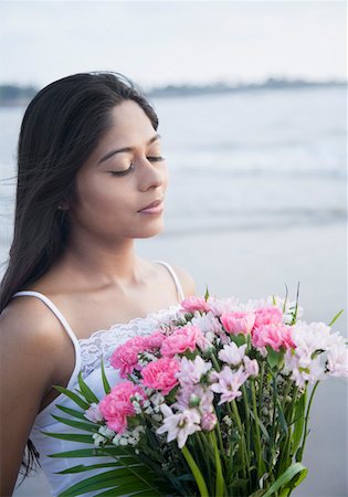 day dreaming eyes - Close-up of a young woman holding a bouquet of flowers and standing with her eyes closed Stock Photo - Premium Royalty-Free, Code: 630-01875180