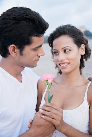 Side profile of a young man giving a flower to a young woman Stock Photo - Premium Royalty-Free, Code: 630-01875205