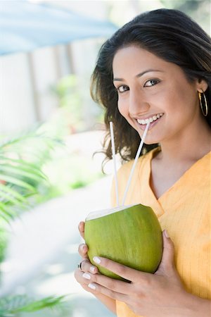 Portrait of a young woman drinking coconut milk Stock Photo - Premium Royalty-Free, Code: 630-01875235