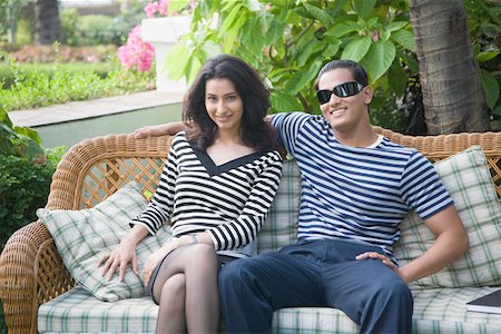 Jeune couple assis sur un canapé et souriant Photographie de stock - Premium Libres de Droits, Code: 630-01875287