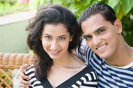 Portrait of a young man with his arm around a young woman and smiling Stock Photo - Premium Royalty-Free, Code: 630-01875293