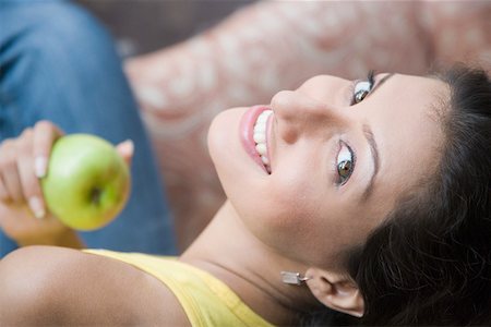simsearch:630-01128103,k - Portrait of a young woman holding a granny smith apple and smiling Stock Photo - Premium Royalty-Free, Code: 630-01875323