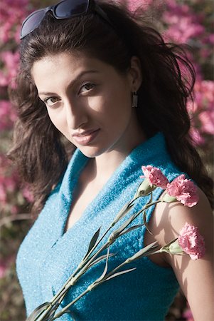 simsearch:630-01129601,k - Portrait of a young woman holding flowers and smiling Foto de stock - Royalty Free Premium, Número: 630-01875414