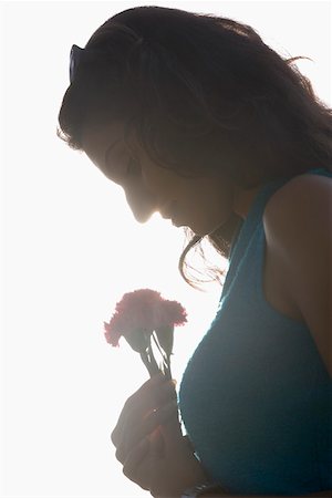 simsearch:630-01129601,k - Side profile of a young woman holding flowers and smiling Foto de stock - Royalty Free Premium, Número: 630-01875419