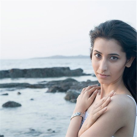 Portrait of a young woman with her arms crossed on the beach Stock Photo - Premium Royalty-Free, Code: 630-01875499