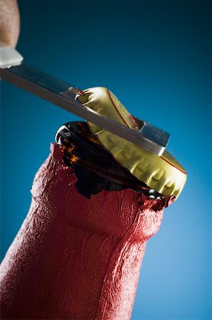 Close-up of a person opening a beer bottle with a bottle opener Foto de stock - Royalty Free Premium, Número: 630-01875794