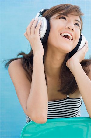 simsearch:630-01876148,k - Close-up of a young woman listening to music and smiling Foto de stock - Sin royalties Premium, Código: 630-01876164