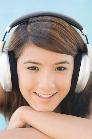 Portrait d'une jeune femme à l'écoute de musique et souriant Photographie de stock - Premium Libres de Droits, Code: 630-01876167
