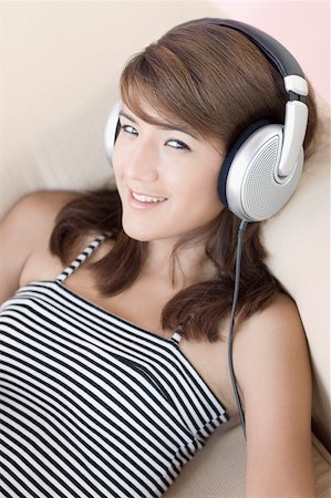 simsearch:630-01876148,k - Portrait of a young woman listening to music and smiling Foto de stock - Sin royalties Premium, Código: 630-01876161