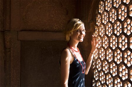 Portrait d'une jeune femme debout près d'une fenêtre et souriant, Taj Mahal, Agra, Uttar Pradesh, Inde Photographie de stock - Premium Libres de Droits, Code: 630-01876344