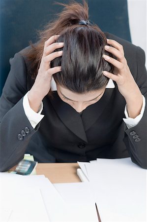 frustrated office worker with hands in hair - Businesswoman sitting with her head in her hands Stock Photo - Premium Royalty-Free, Code: 630-01876376