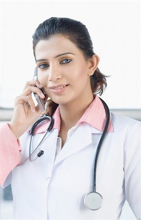 Portrait of a female doctor talking on a mobile phone Foto de stock - Sin royalties Premium, Código: 630-01876395