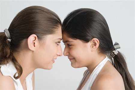 Gros plan d'une fille avec sa mère, regardant les uns les autres et souriant Photographie de stock - Premium Libres de Droits, Code: 630-01876431