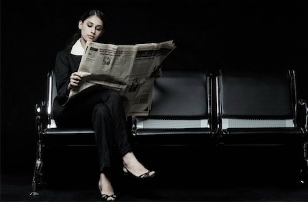 Businesswoman sitting on a bench and reading a newspaper Stock Photo - Premium Royalty-Free, Code: 630-01876475