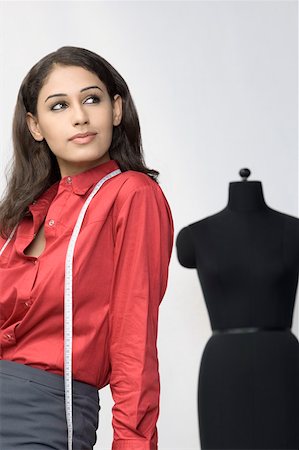 designer indian garment - Side profile of a female designer with a measuring tape around her neck Stock Photo - Premium Royalty-Free, Code: 630-01876601