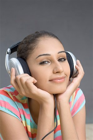 simsearch:630-01876536,k - Portrait of a young woman listening to music and smirking Stock Photo - Premium Royalty-Free, Code: 630-01876628