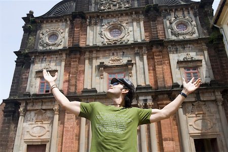 simsearch:630-01876662,k - Young man standing in front of a building with his arms outstretched, Goa, India Stock Photo - Premium Royalty-Free, Code: 630-01876661