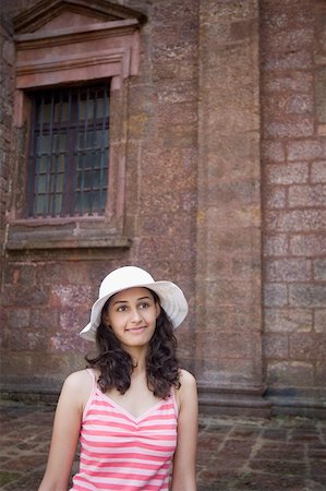 Young woman smirking in front of a wall, Goa, India Stock Photo - Premium Royalty-Free, Code: 630-01876684