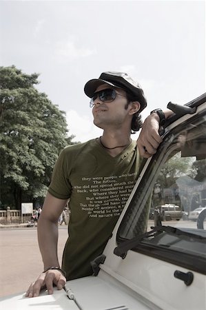 Young man standing by a jeep, Goa India Stock Photo - Premium Royalty-Free, Code: 630-01876709