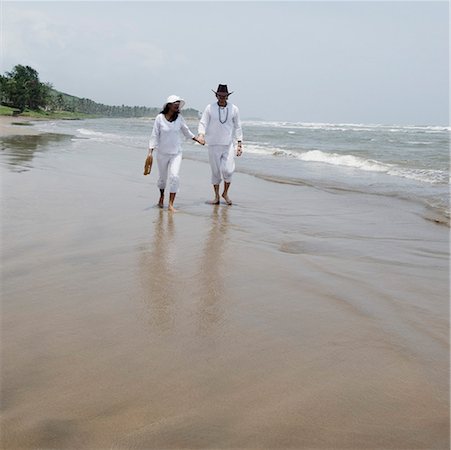 simsearch:630-01877048,k - Young couple walking with holding hands on the beach Foto de stock - Sin royalties Premium, Código: 630-01876772