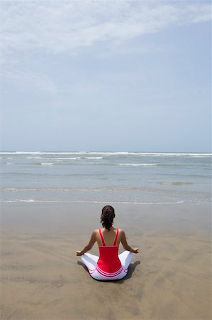 Rear view of a young woman meditating Stock Photo - Premium Royalty-Free, Code: 630-01876789