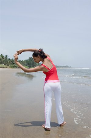 exercise black people water - Rear view of a young woman exercising on the beach Stock Photo - Premium Royalty-Free, Code: 630-01876782