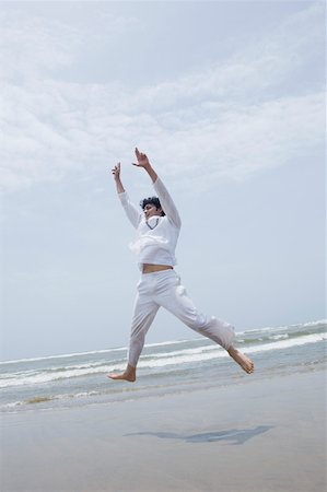 simsearch:630-01877039,k - Young man exercising on the beach Fotografie stock - Premium Royalty-Free, Codice: 630-01876796