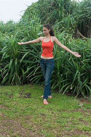 simsearch:630-01876535,k - Young woman standing with her arms outstretched in a garden Stock Photo - Premium Royalty-Free, Code: 630-01876836