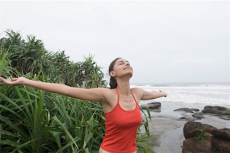 simsearch:640-03260389,k - Young woman standing on the beach with her arms outstretched Stock Photo - Premium Royalty-Free, Code: 630-01876856