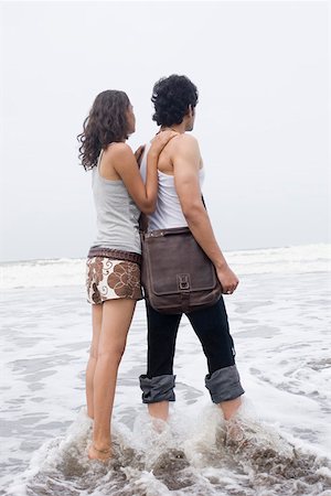 rolled up pants - Side profile of a young couple standing on the beach Stock Photo - Premium Royalty-Free, Code: 630-01876889