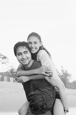 simsearch:630-01876927,k - Young man smiling and piggybacking a young woman on his back Stock Photo - Premium Royalty-Free, Code: 630-01876935