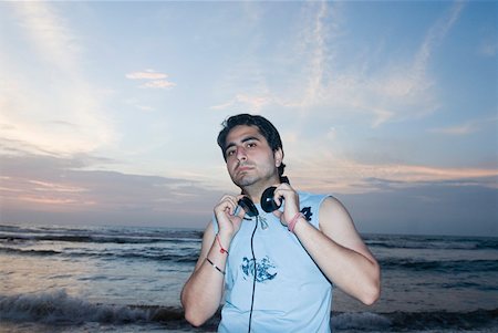 Portrait of a young man with headphones around his neck Stock Photo - Premium Royalty-Free, Code: 630-01876953