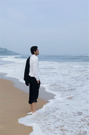 Side profile of a businessman standing on the beach Stock Photo - Premium Royalty-Free, Code: 630-01877036