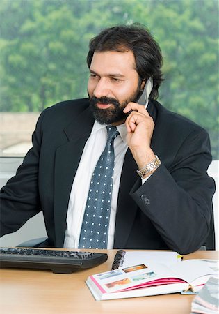 simsearch:630-01873878,k - Businessman talking on a mobile phone and smiling Stock Photo - Premium Royalty-Free, Code: 630-01877086