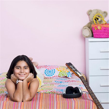 simsearch:630-01876447,k - Portrait of a girl lying on the bed and smiling Foto de stock - Royalty Free Premium, Número: 630-01877097