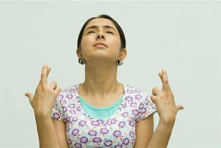 Close-up of a young woman with her fingers crossed Foto de stock - Royalty Free Premium, Número: 630-01877122