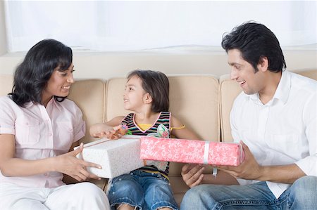 Mid adult man and a young woman giving gifts to their daughter Foto de stock - Sin royalties Premium, Código: 630-01877181