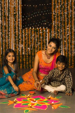 deepawali celebration girls - Young woman making a rangoli with her son and daughter Stock Photo - Premium Royalty-Free, Code: 630-01877284