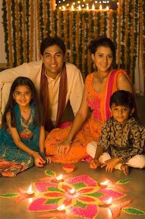 family celebrating diwali - Young couple sitting with their children in front of rangoli Stock Photo - Premium Royalty-Free, Code: 630-01877286