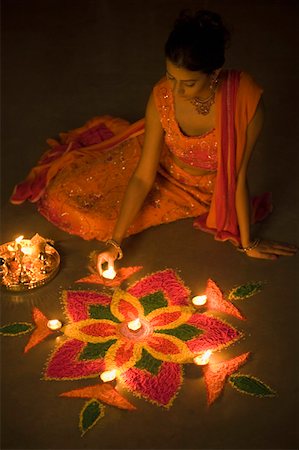 deepavali lamp - High angle view of a young woman decorating rangoli with oil lamps Stock Photo - Premium Royalty-Free, Code: 630-01877280