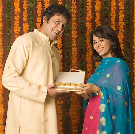 diwali couple sweet photos - Portrait of a mid adult man and a young woman holding a sweet box Foto de stock - Sin royalties Premium, Código: 630-01877314