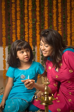 diwali little girl - Side profile of a young woman holding a traditional diwali lamp and her daughter looking at her Stock Photo - Premium Royalty-Free, Code: 630-01877310