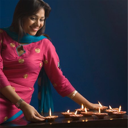 simsearch:630-01876241,k - Close-up of a young woman looking at oil lamps and smiling Fotografie stock - Premium Royalty-Free, Codice: 630-01877370