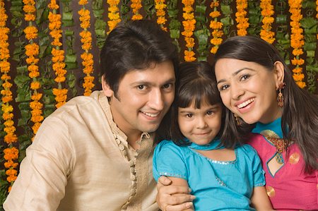 family celebrating diwali - Portrait of a girl smiling between her parents Stock Photo - Premium Royalty-Free, Code: 630-01877403