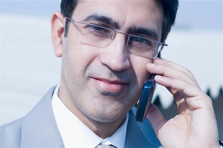 Close-up of a businessman talking on a mobile phone Stock Photo - Premium Royalty-Free, Code: 630-01877444