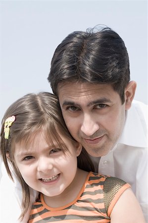 Portrait of a mid adult man smiling with his daughter Stock Photo - Premium Royalty-Free, Code: 630-01877456